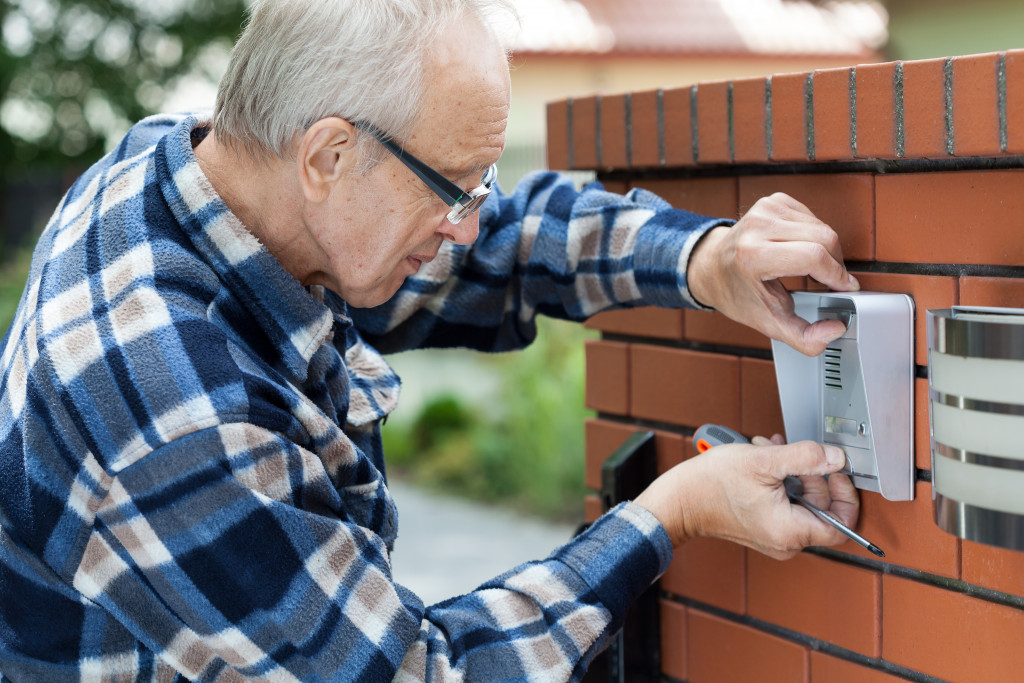 doorbell being installed by an elderly man