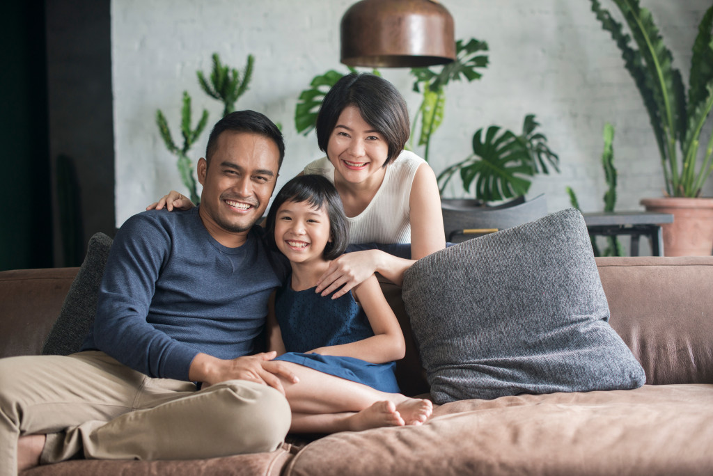 Asian family smiling while chilling in their living room