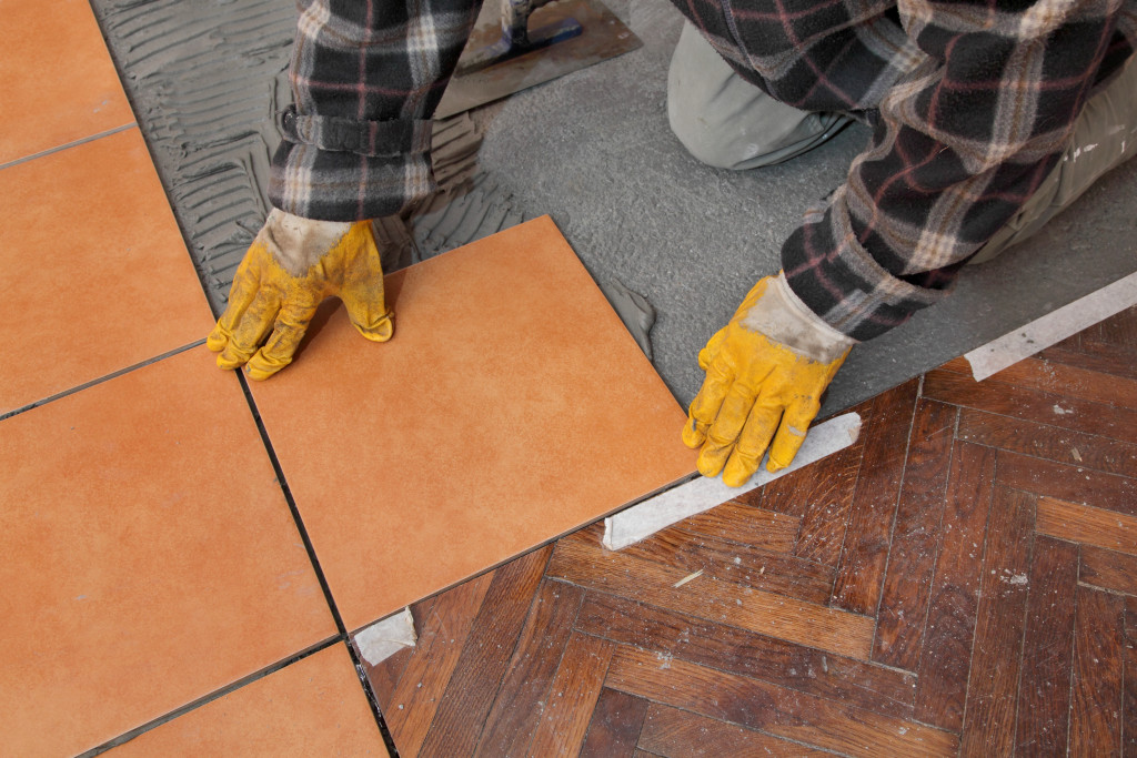 man putting floor tiles