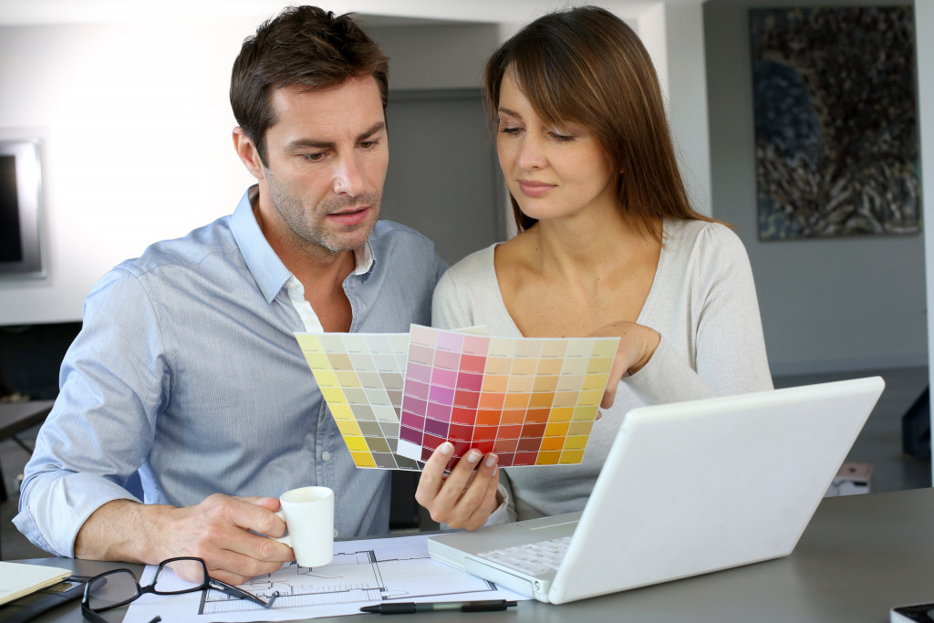 Man with with his wife selecting a color for their house 