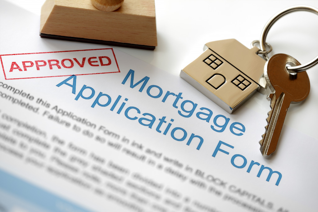 a mortgage document application with approved stamp and house keys