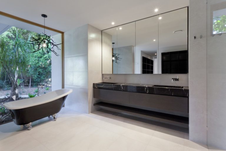 A modern luxury bathroom with sink, mirror, and bathtub