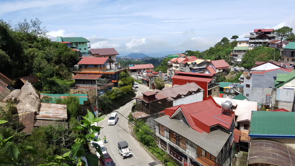Philippines town of Baguio with houses and vehicles safely driving down the winding road