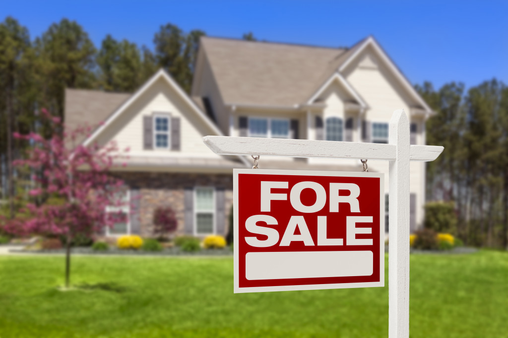 For sale sign in front of a country home.