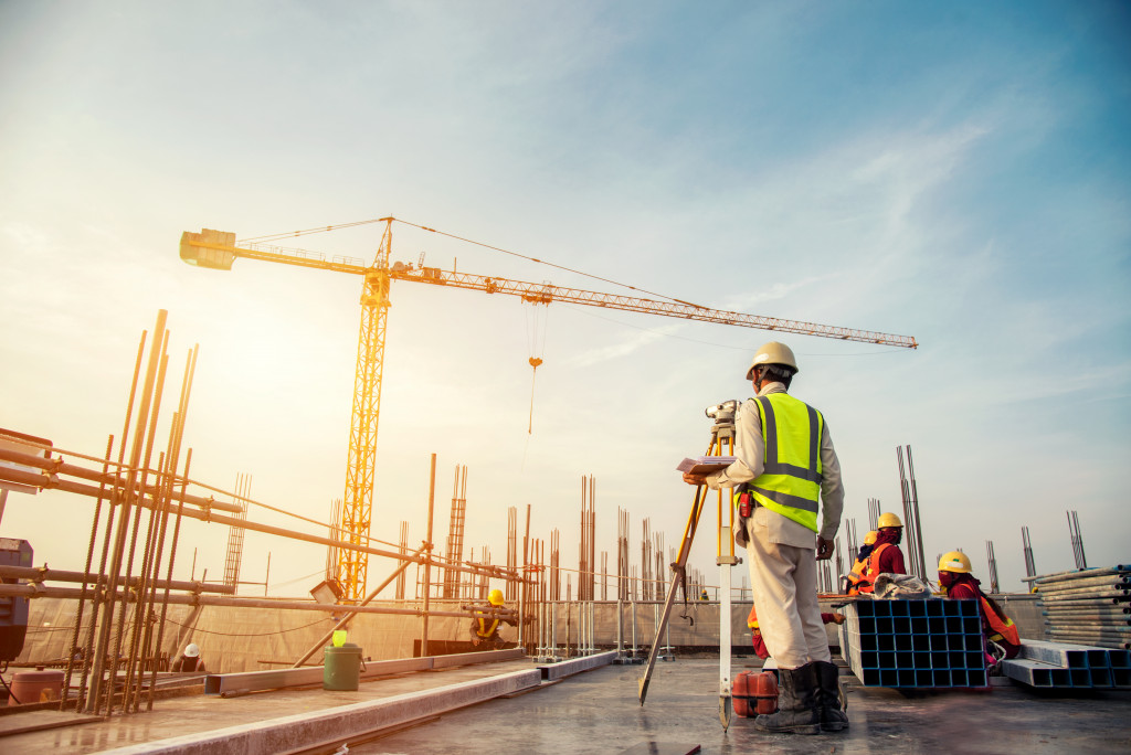 An image of a construction site with workers and a crane