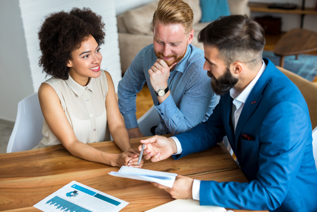 Young couple talking with a real estate agent.