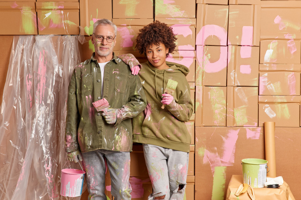 man and a woman painting the house