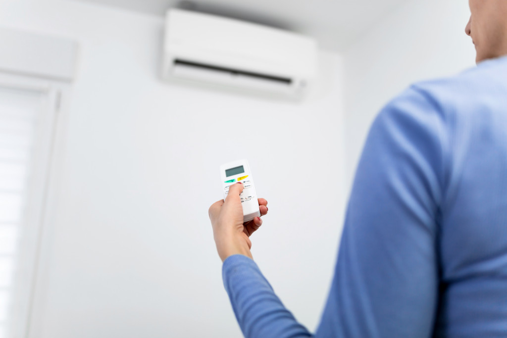 An image of a woman setting an air conditioner at home