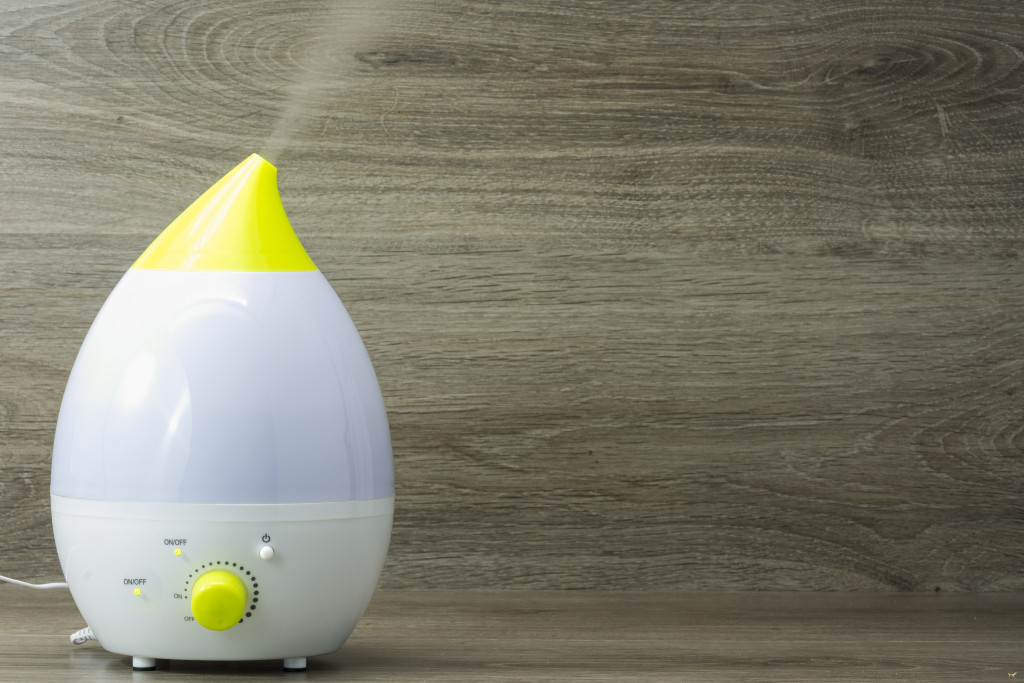 Humidifier inside a home in front of a wooden background.
