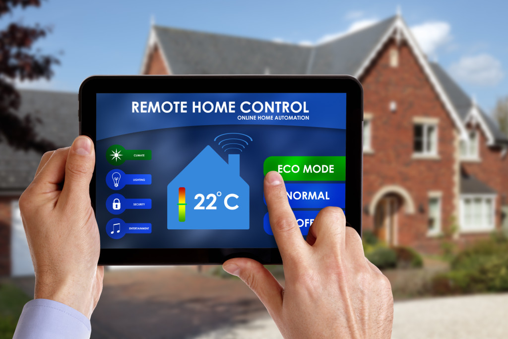 Person controlling the temperature inside a home using a tablet.