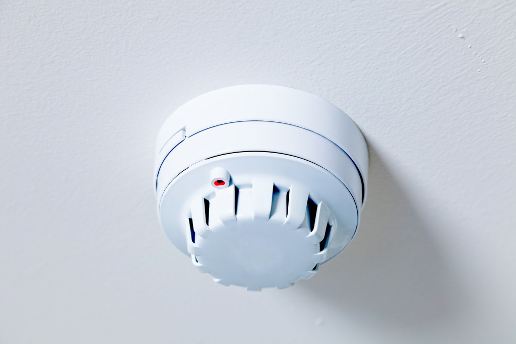 A white smoke detector on the ceiling
