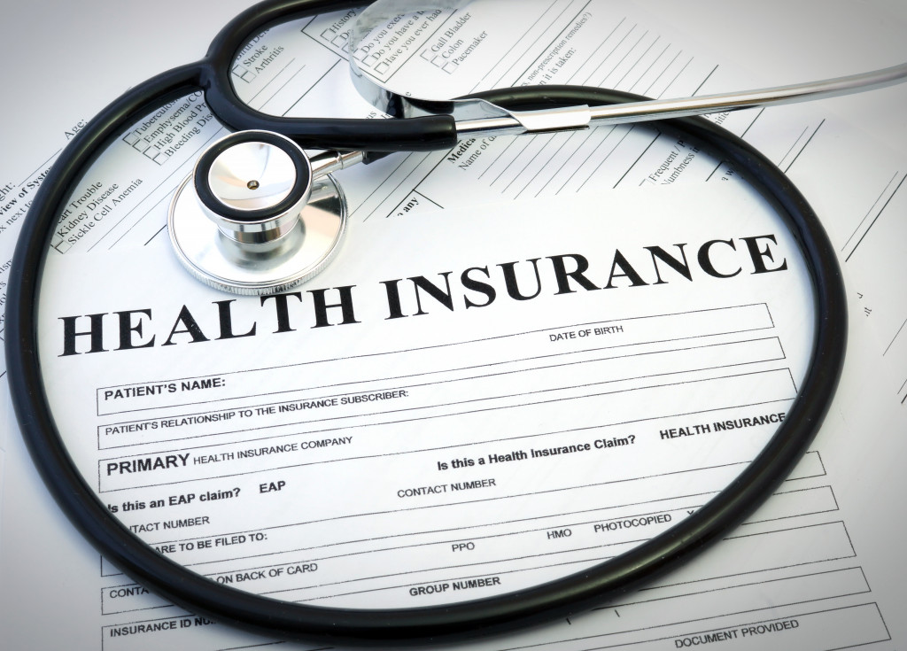 a health insurance document and a stethoscope